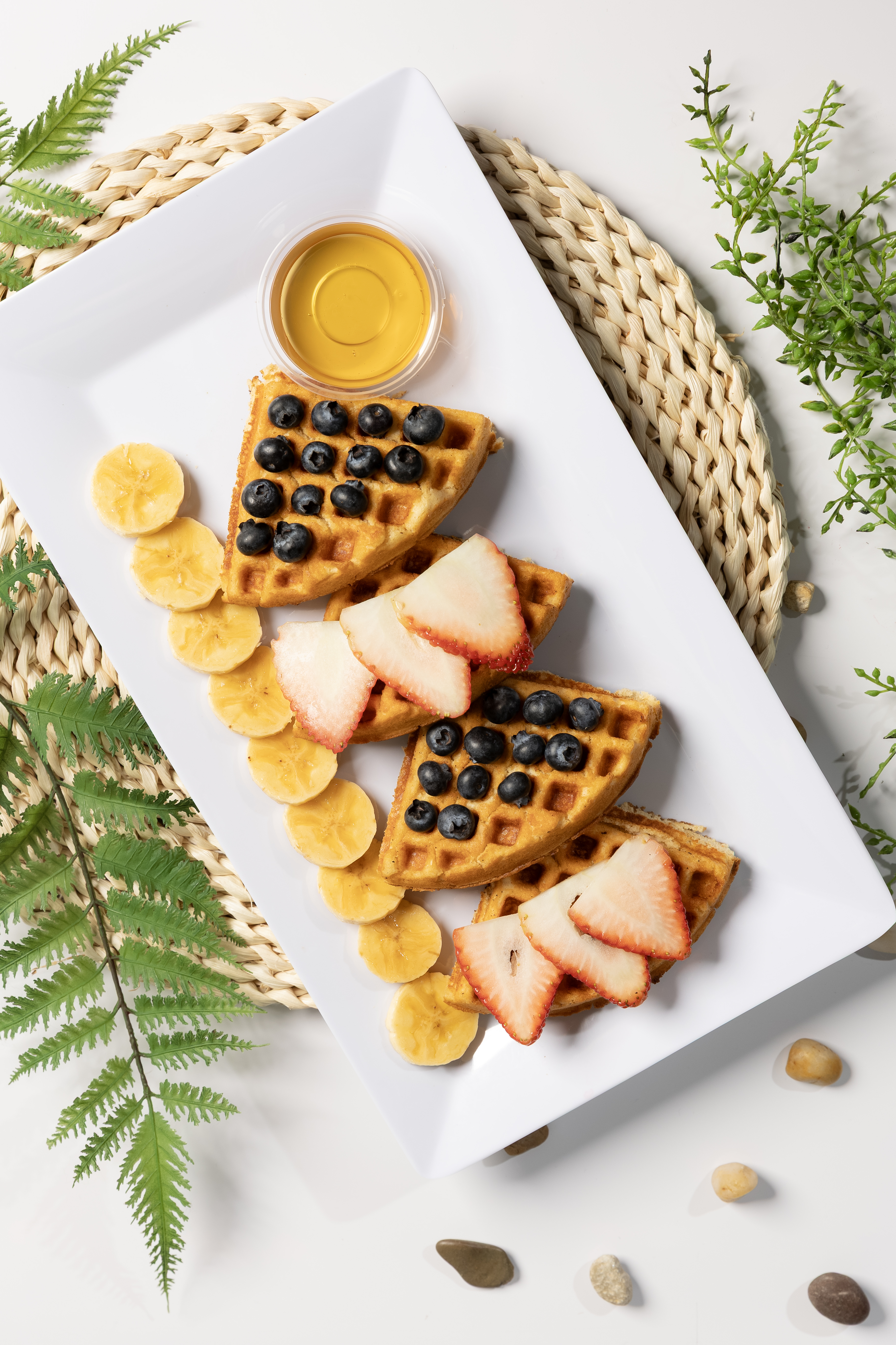 Waffles con blueberries, fresas y banana en vista aérea